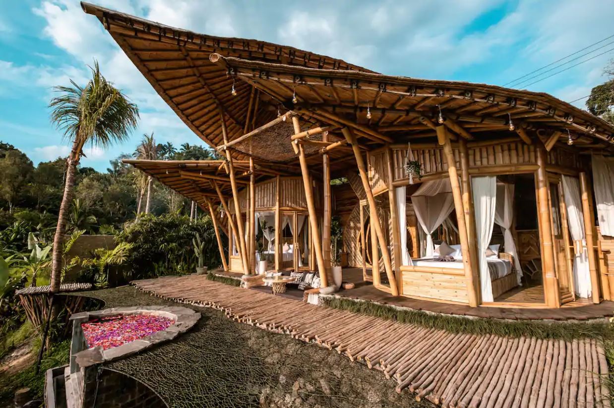 Das Äußere eines Open-Air-Bambushauses in Bali mit Whirlpool im Freien